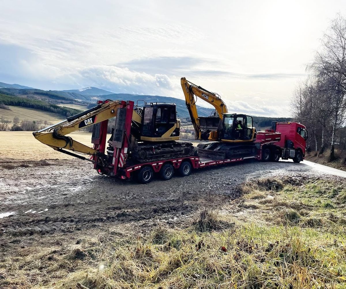 Podvalník ASTRID s pásovými rypadly CAT a JCB na stavbě v terénu