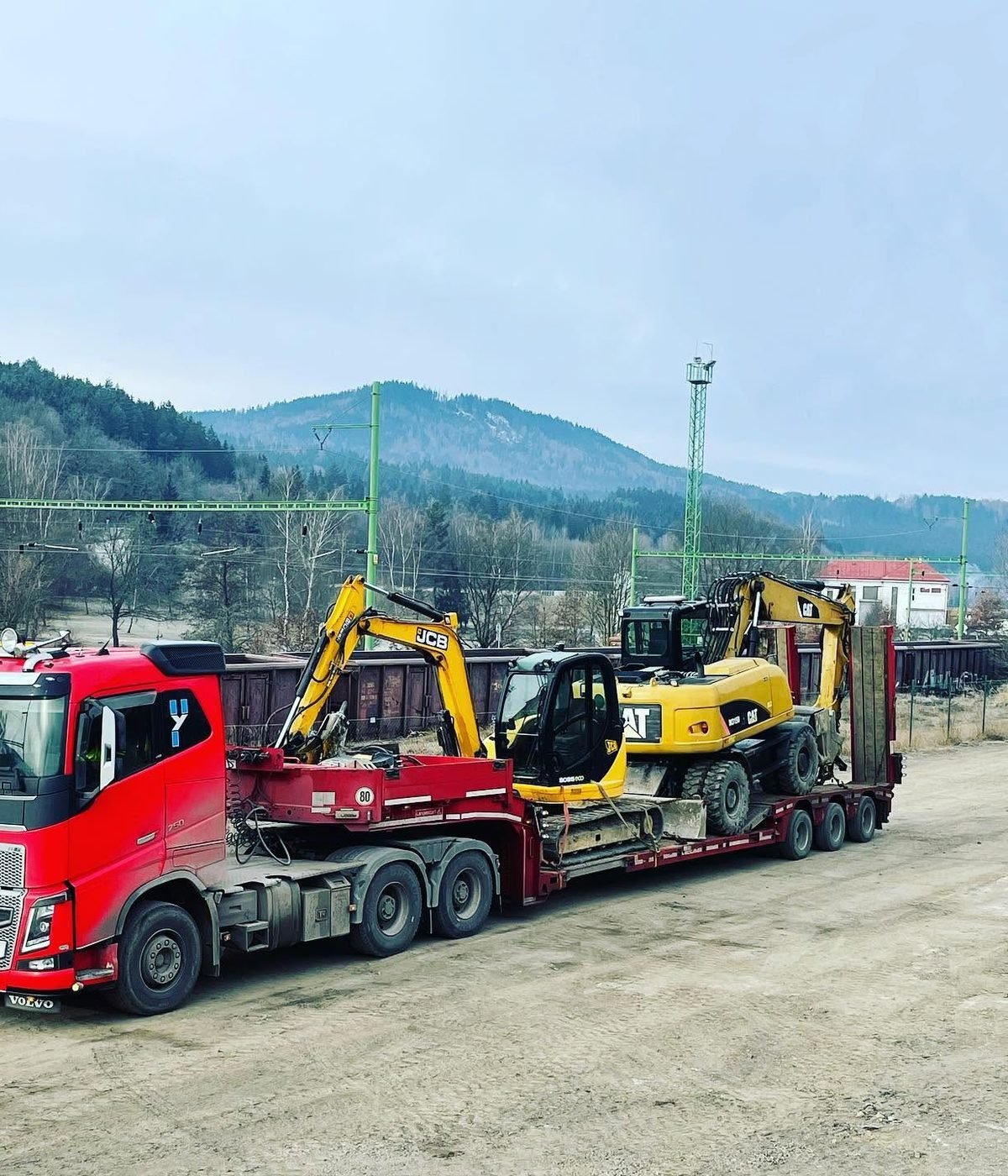 Rypadla CAT a JCB naložená na podvalníku ASTRID
